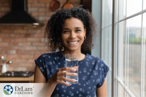 An image of a woman holding up a glass of water