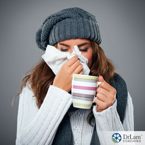An image of a woman bundled up sneezing from a cold