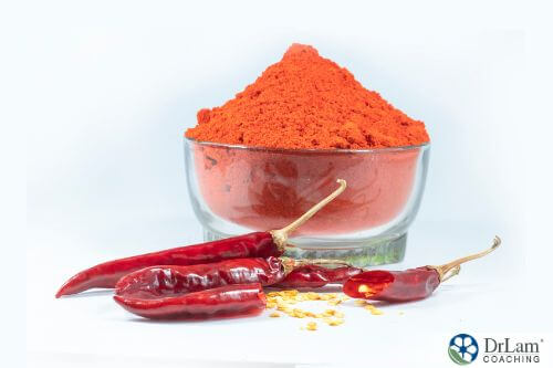An image of red chili peppers and a bowl of chili powder