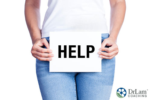An image of a woman holding a help sign in front of her bladder area